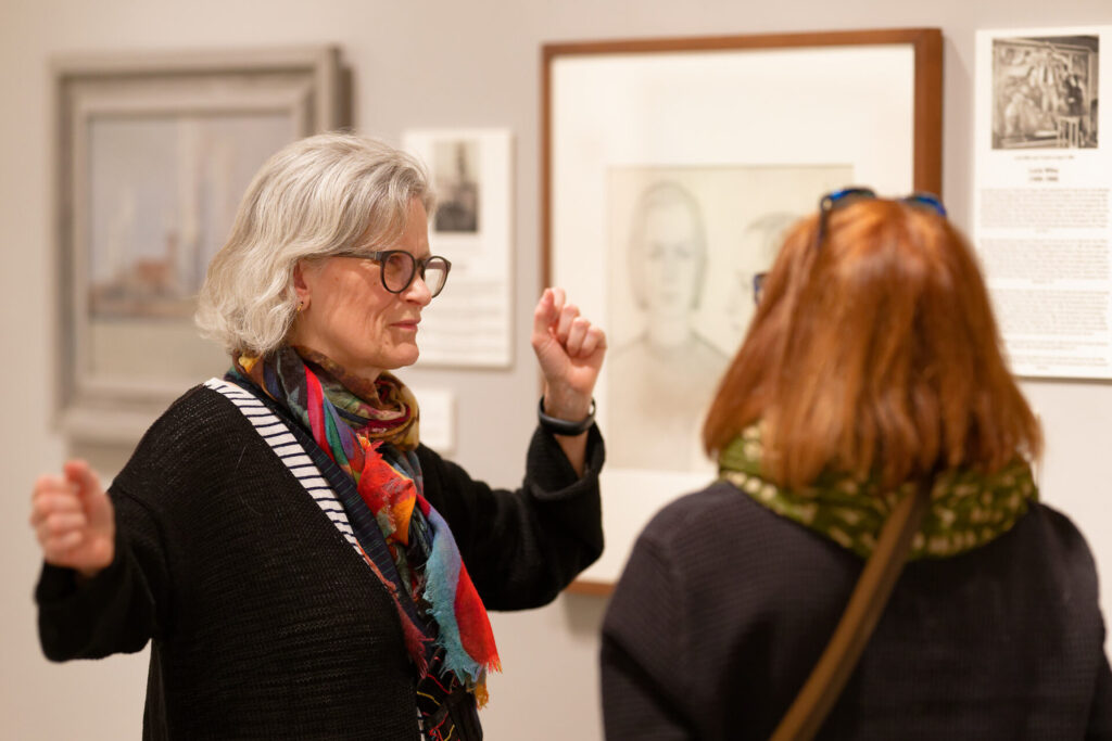 Museum visitors discussing artwork in a gallery